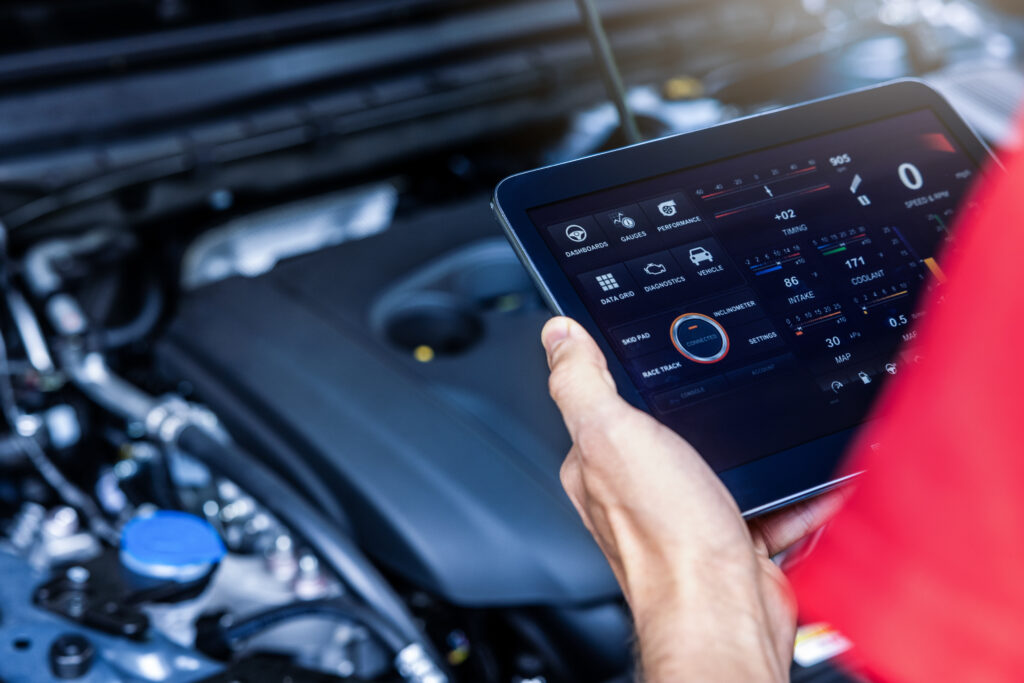 Mechanic using professional diagnostic equipment on a car, illustrating the superiority of comprehensive vehicle diagnostics over basic code-pulling services.